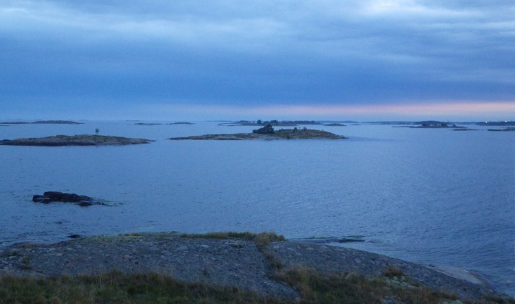 Bild. Öar i havet. Ljus från Oxelösund i fjärran.