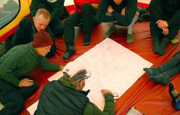 Bild. Deltagarna sitter i ett tält. En karta ligger på golvet.